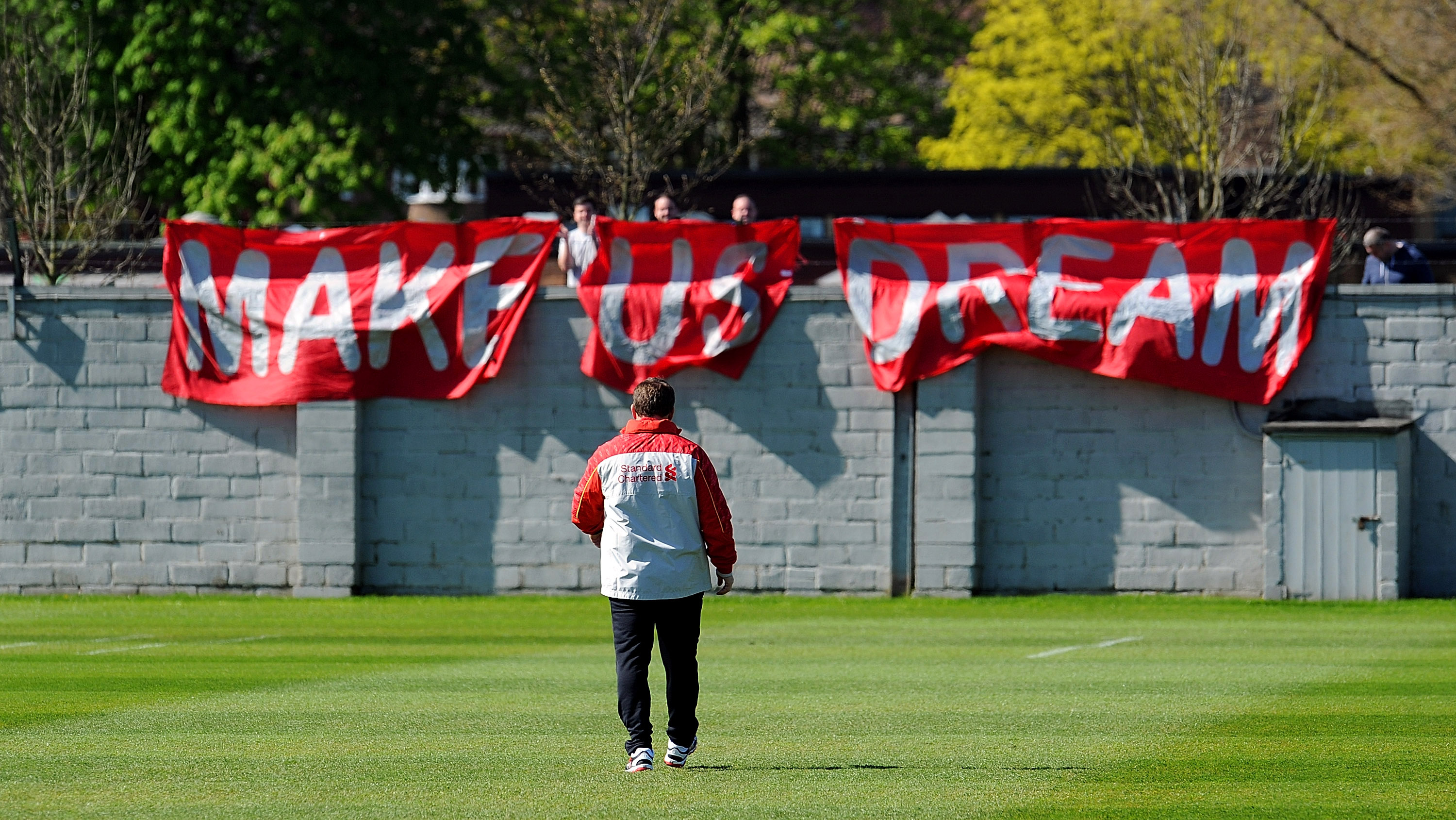 MAKE US DREAM: Supportere var så desperate etter gullet at de hang opp motiverende bannere på treningsfeltet Melwood. Her møter Rodgers noen av de fremmøtte.