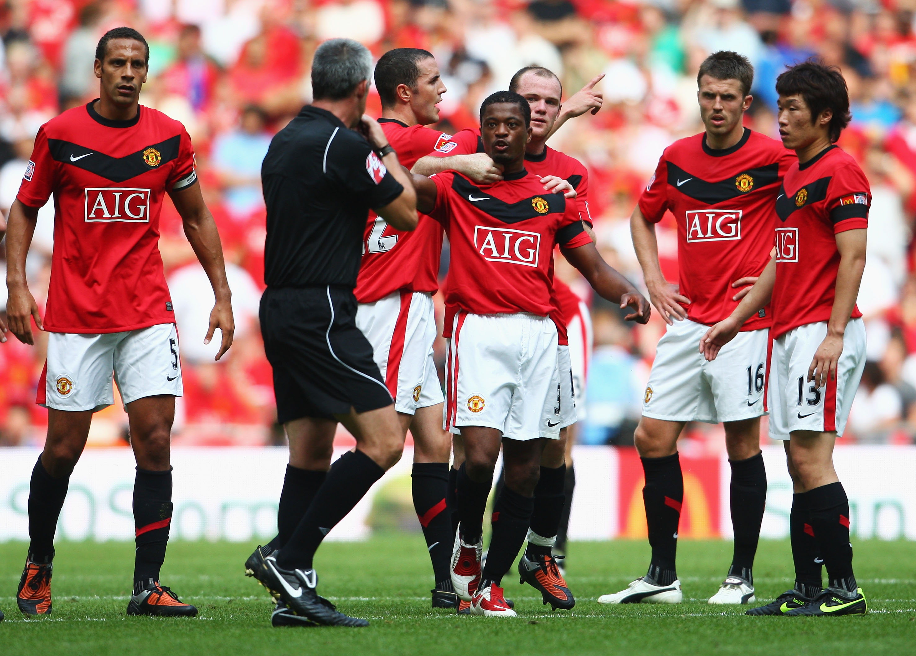 HOLDES IGJEN: Patrice Evra må holdes igjen av lagkameratene, som klaget over dommer Chris Foy under Community Shield-kampen mot Chelsea i 2009.