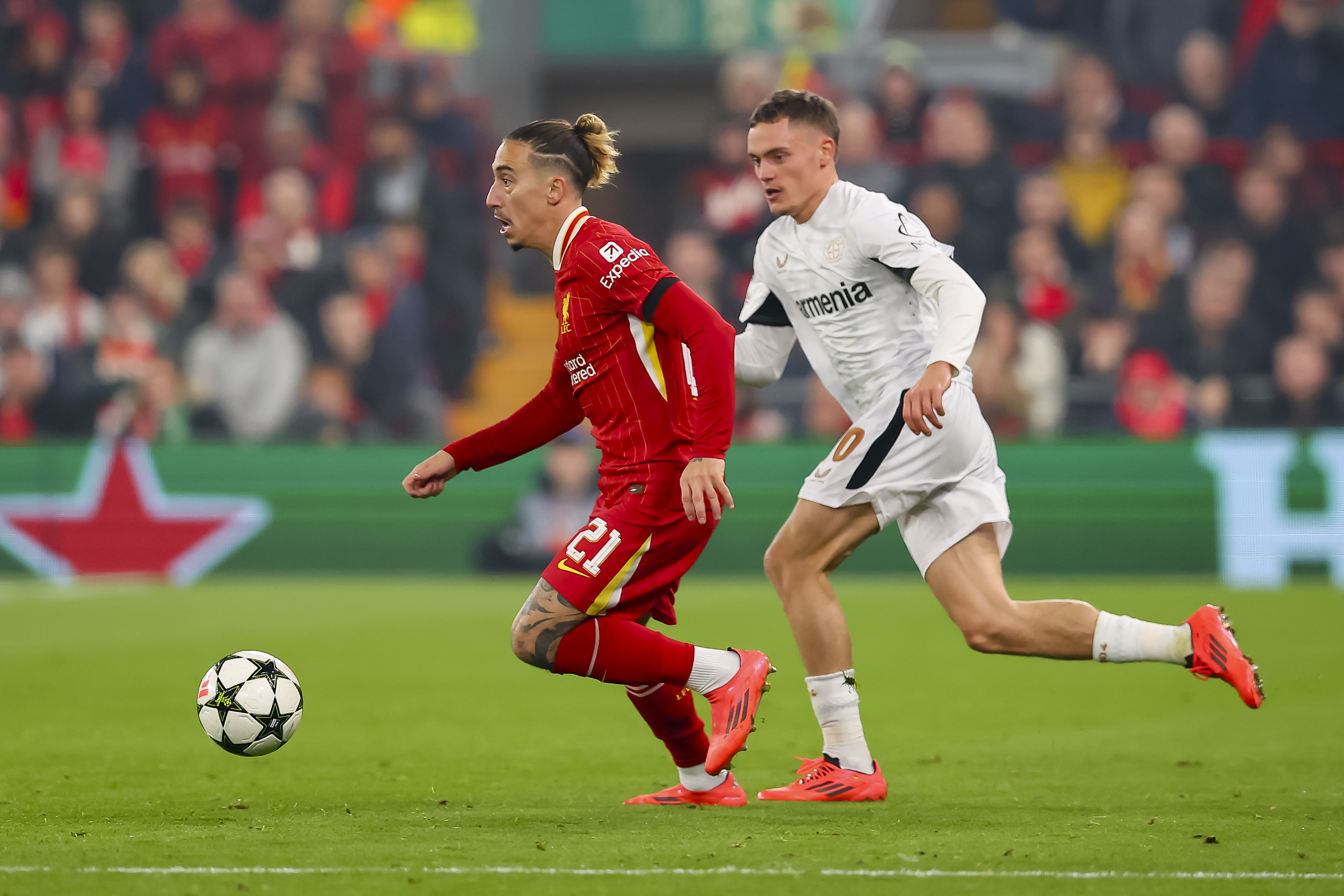 FIKK IKKE LIKE MYE TIL PÅ ANFIELD: Kostas Tsimikas løper foran Florian Wirtz med ballen.